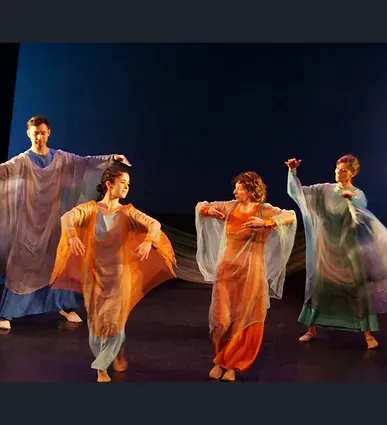 Quatre danseurs d'eurythmie en voiles colorés sur scène