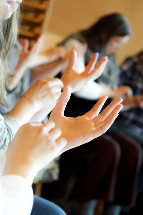 Mains levées en geste, atelier d'eurythmie