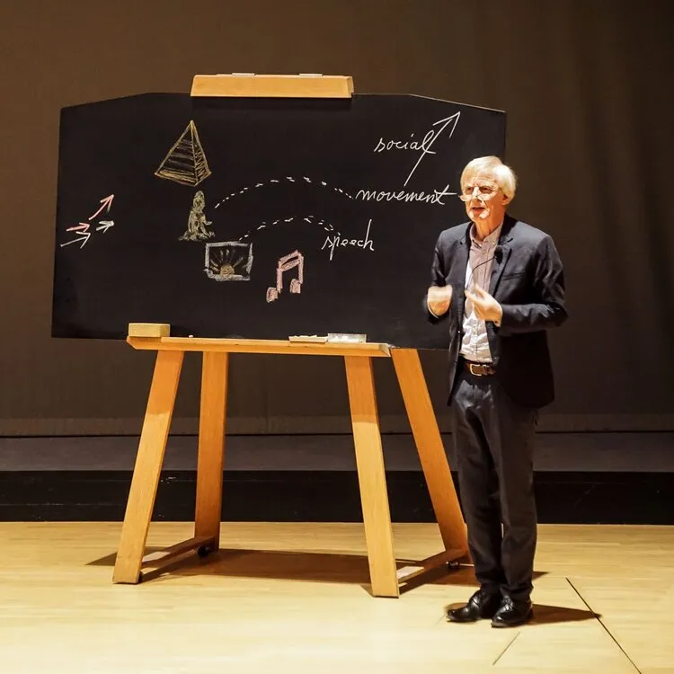 Conférencier devant un tableau noir dessiné à la craie