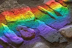 Arc-en-ciel projeté sur une paroi de pierre