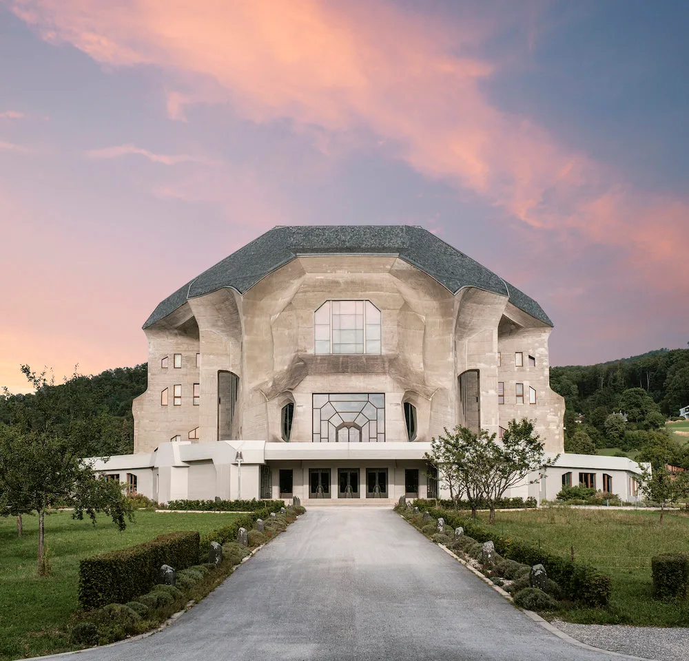 Goetheanum de face au crépuscule, allée bordée d'arbustes