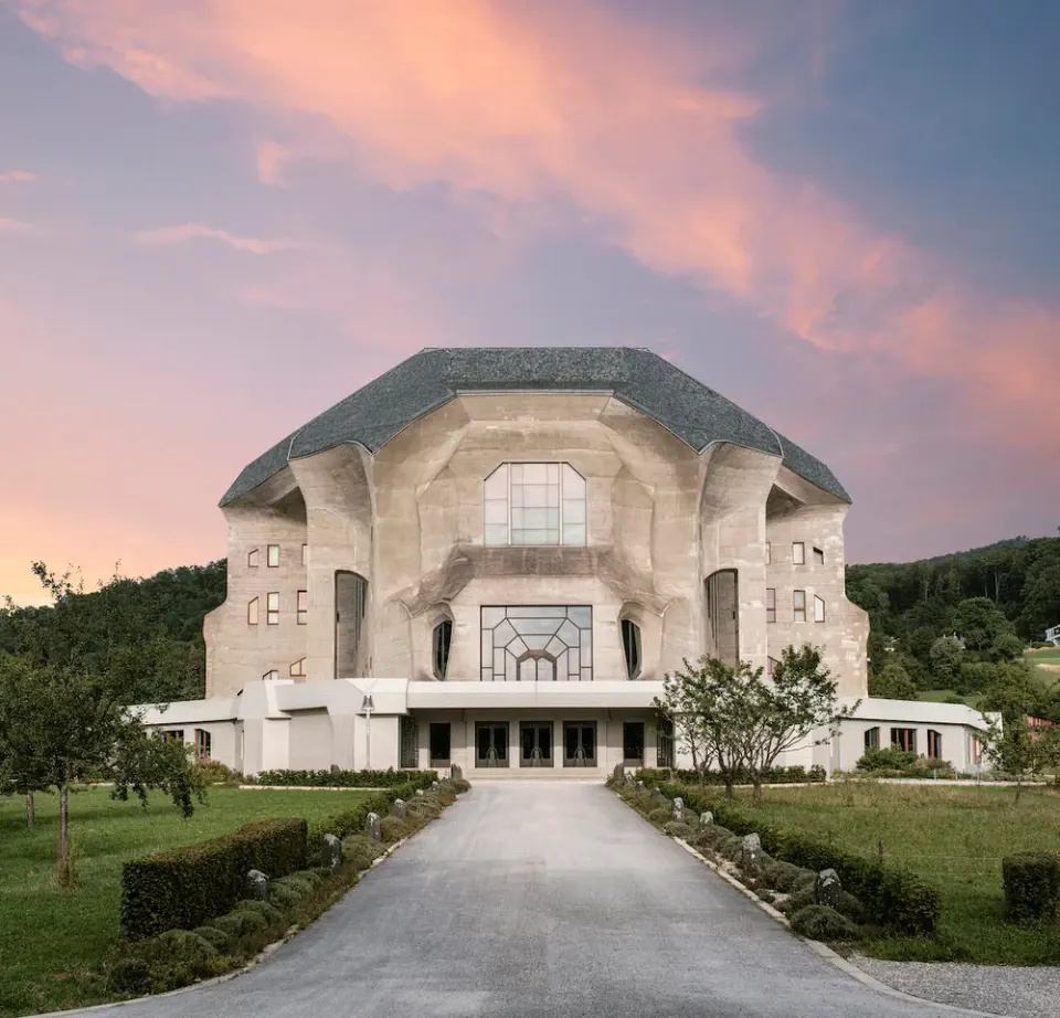 Goetheanum de face au crépuscule, allée bordée d'arbustes