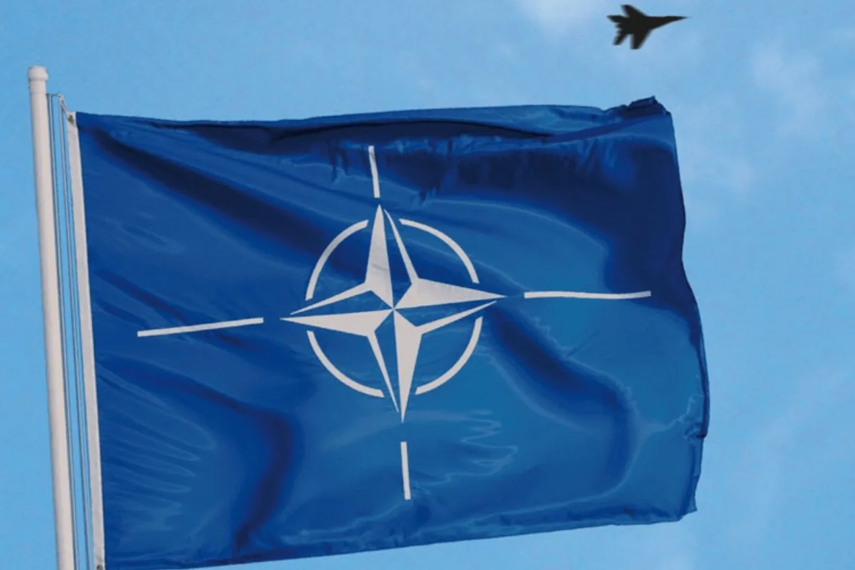 Drapeau de l'OTAN flottant, avion dans le ciel
