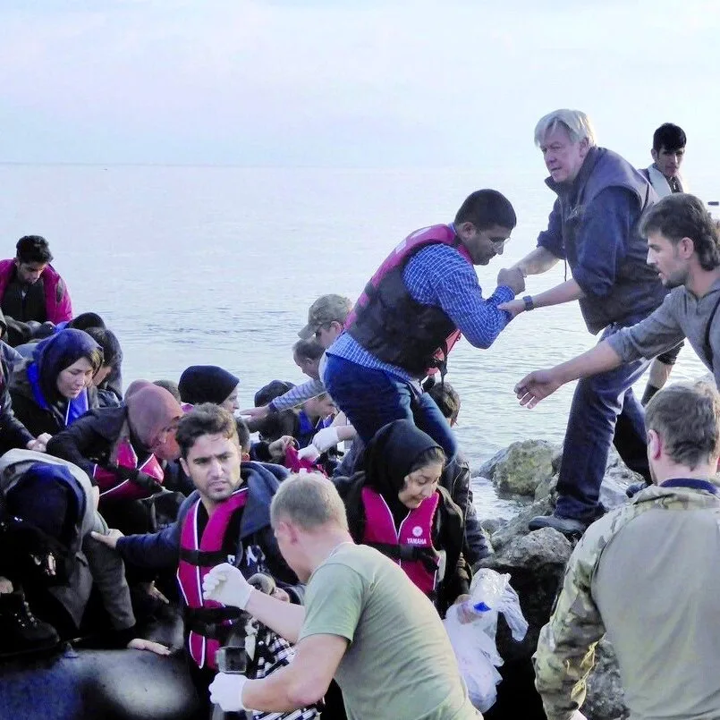 Secours à des migrants débarquant sur un rivage