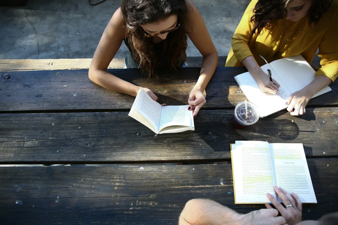 Vue de dessus, trois personnes lisant à une table
