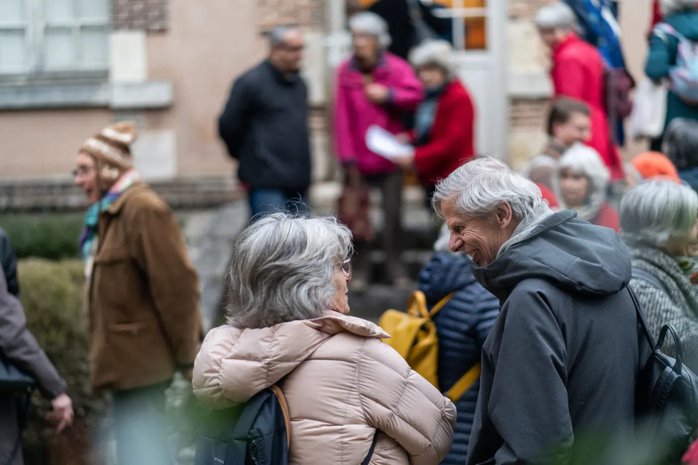 Personnes discutant dehors devant un bâtiment