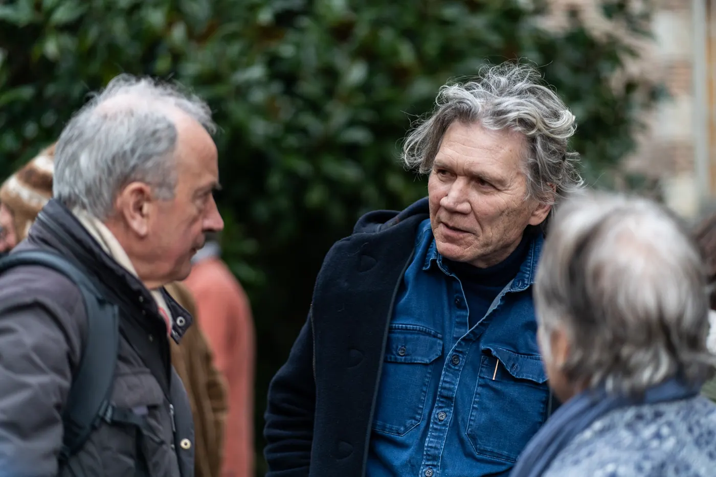 Trois personnes en conversation à l'extérieur