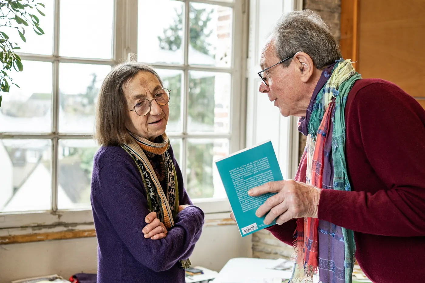 Homme présentant un livre bleu à une femme