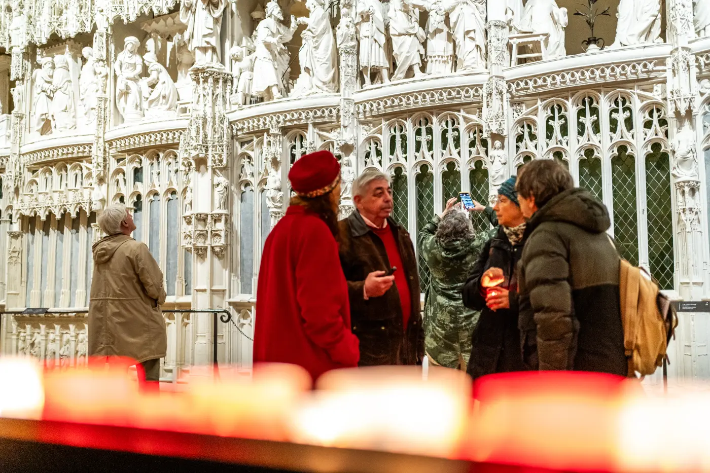Visiteurs devant une clôture sculptée de cathédrale gothique