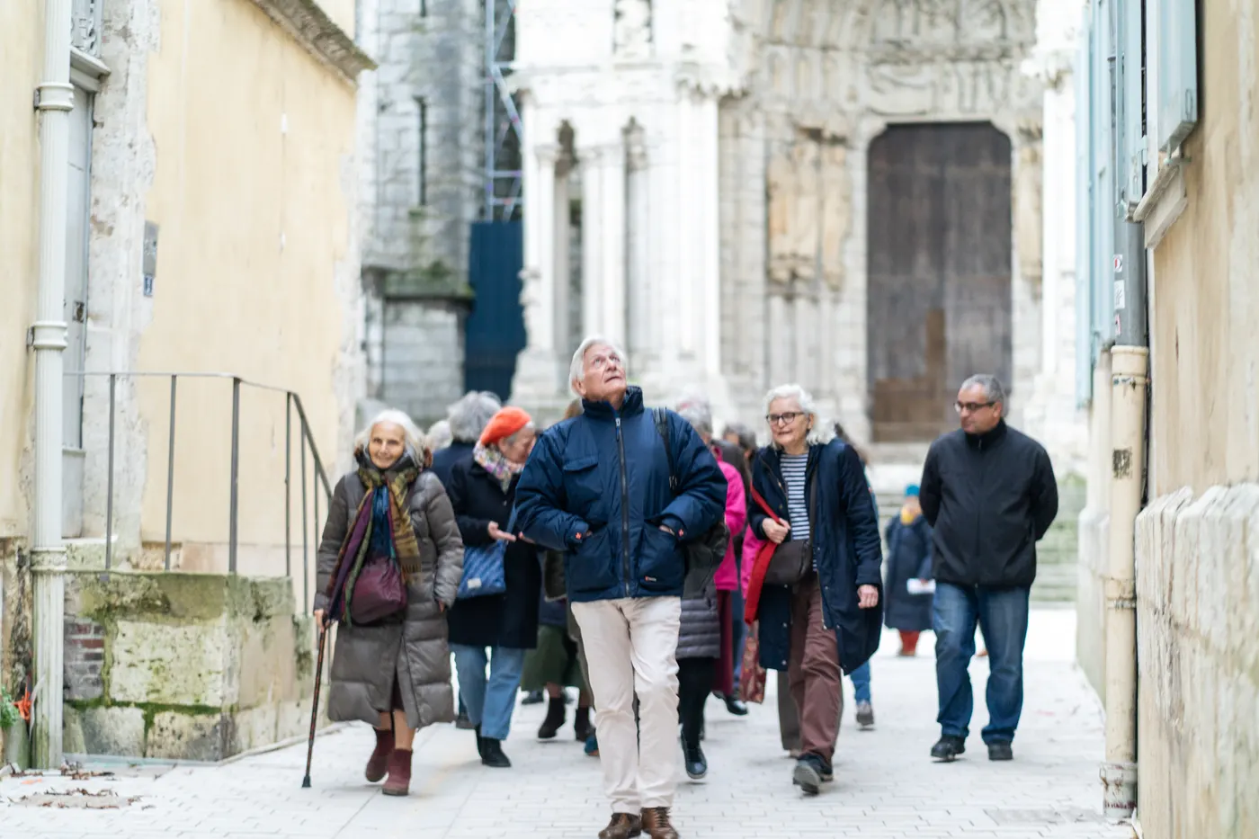 Groupe marchant dans une ruelle près d'une cathédrale