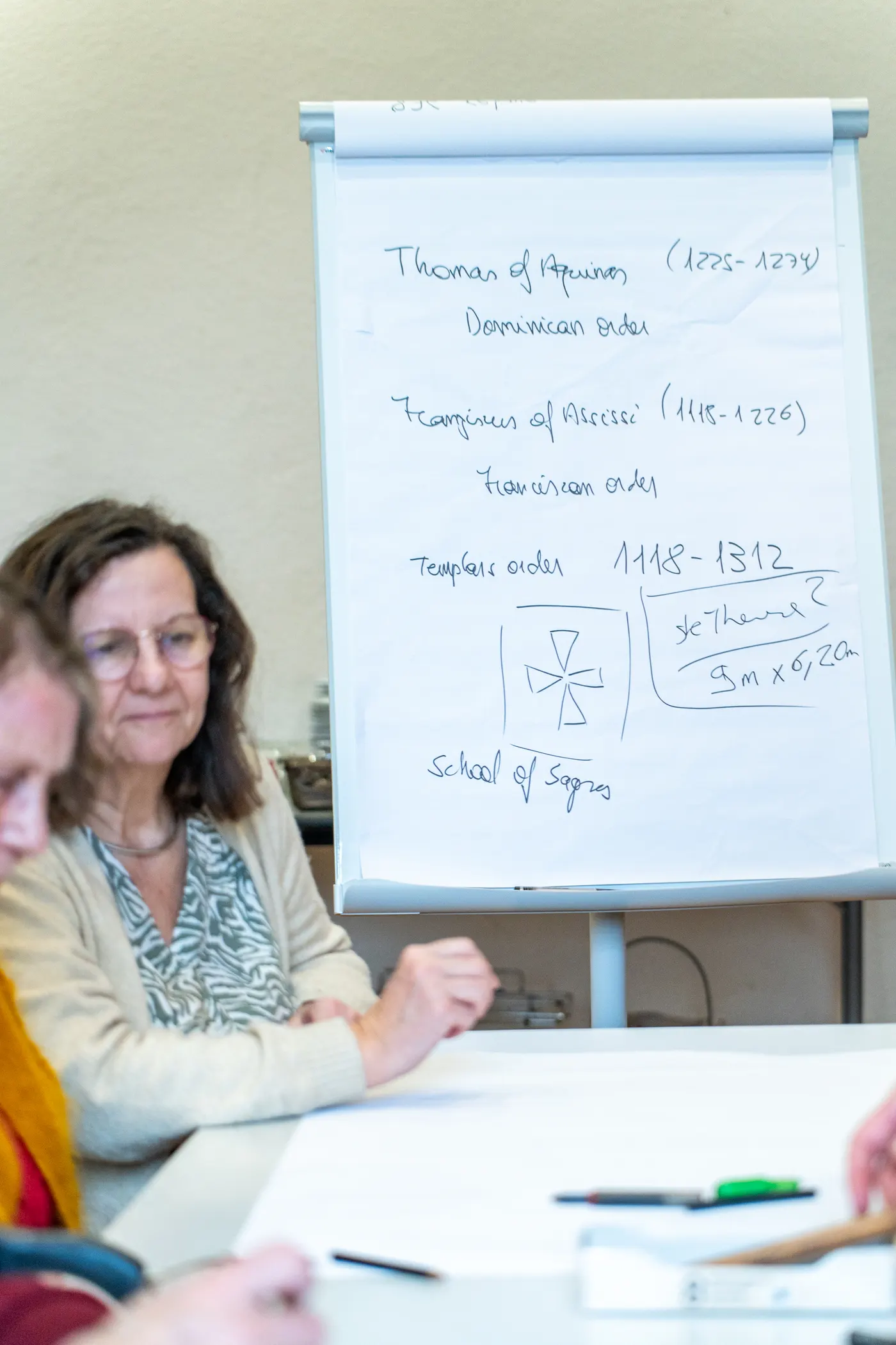 Participante à un séminaire devant un paperboard annoté