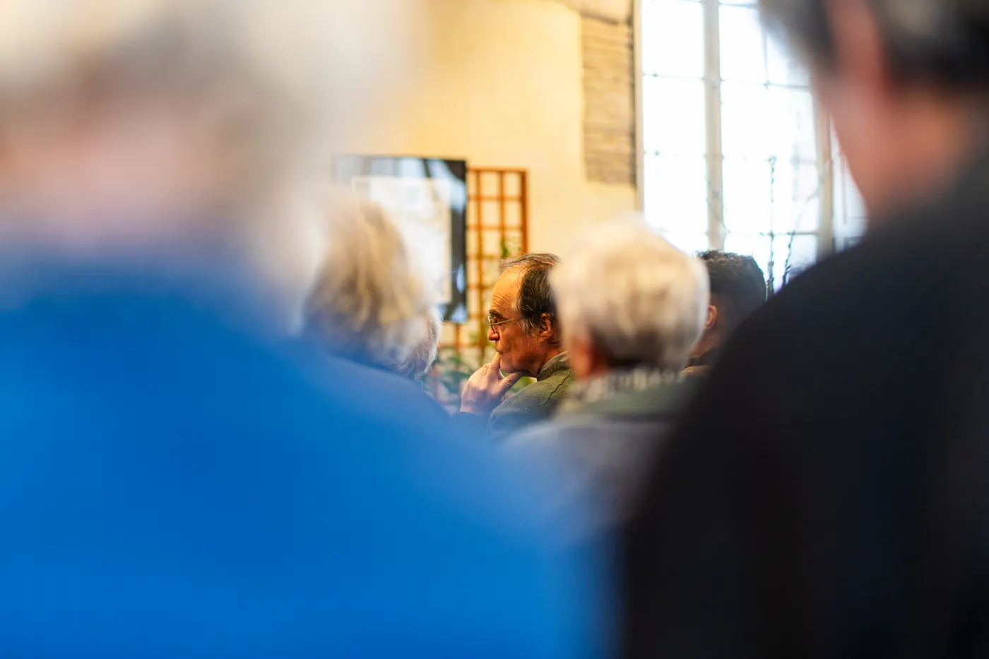 Auditeur pensif entrevu au milieu d'un public flou