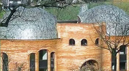 Bâtiment de bois clair coiffé de deux coupoles d'ardoise