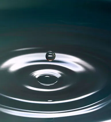Goutte d'eau et ondes concentriques à la surface