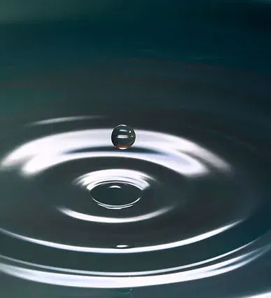 Goutte d'eau et ondes concentriques à la surface